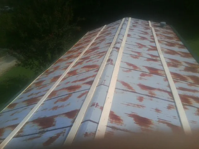 Rusted metal roof panels with new wood purlins before replacement — Storm Damage Roof Repair in Promise City by Roofing Brothers